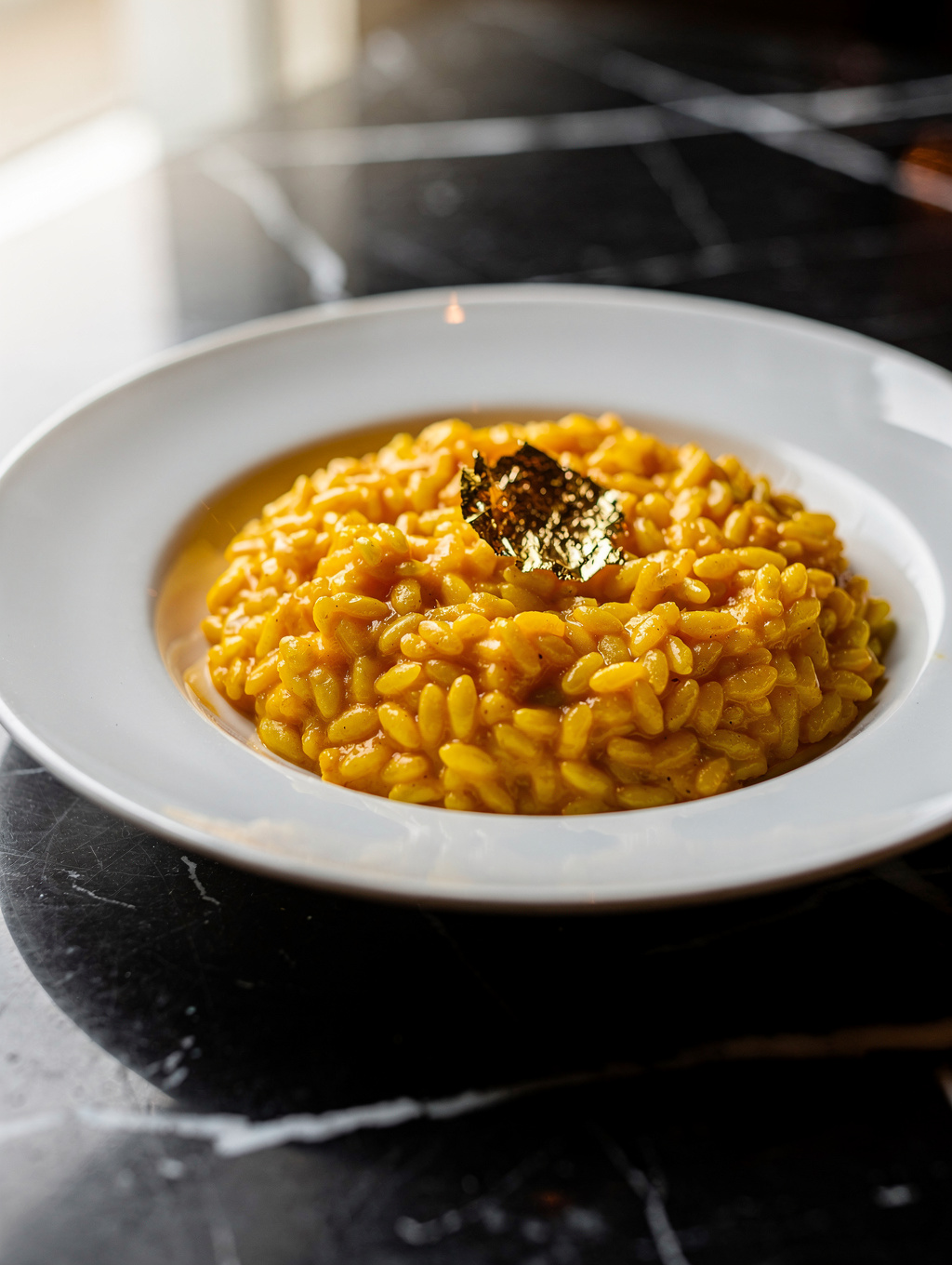 Vibrant golden saffron risotto with caramelized roasted bone marrow